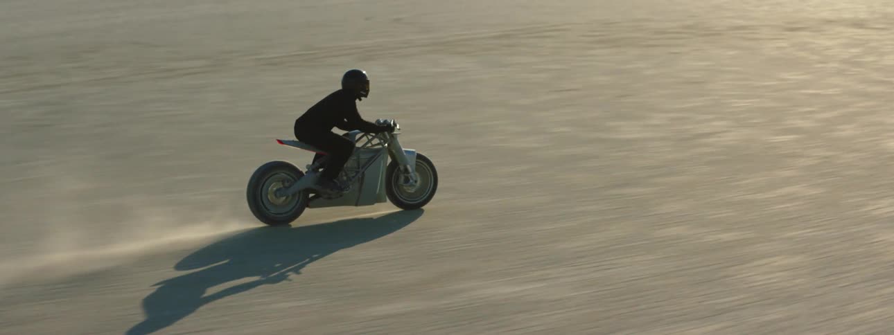 A person is riding their motorcycle in the desert