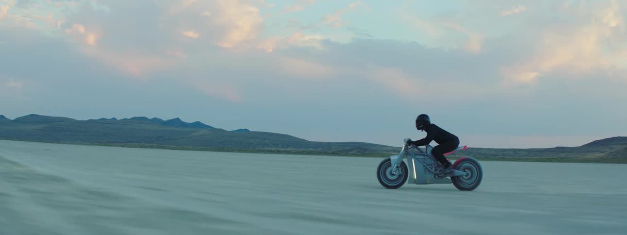 A man is riding a motorcycle through the desert