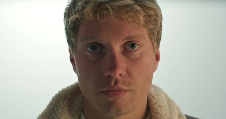 Blonde man looks at camera in the studio