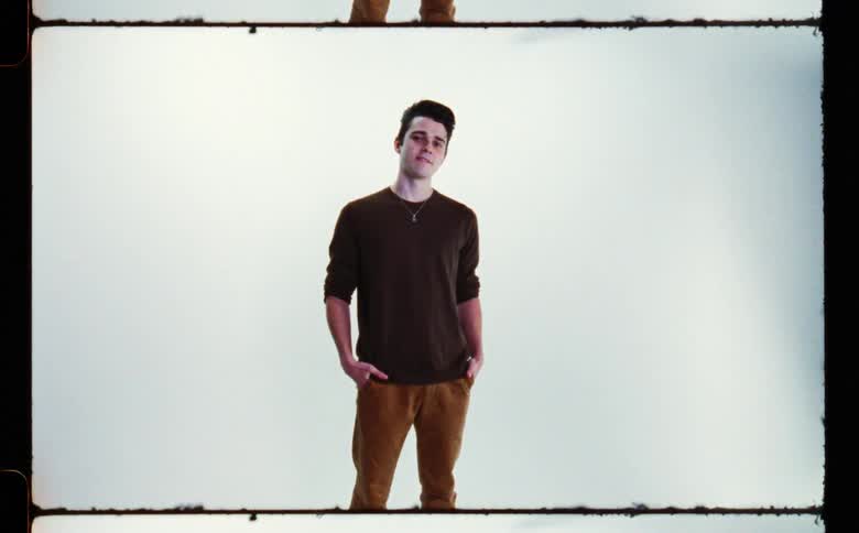 A male is standing with their hand in pockets