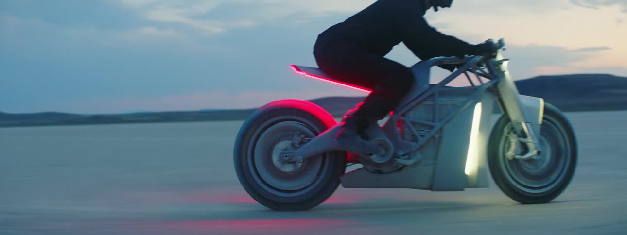 A person rides their motorcycle in the desert