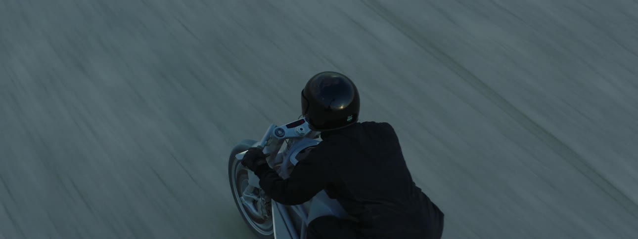 A person rides his motorcycle wearing all black