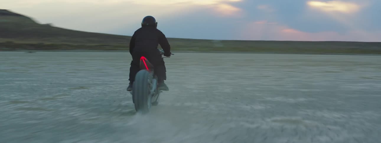 A man is riding his motorcycle vehicle through the wilderness