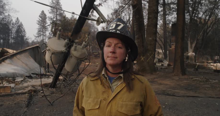 A firefighter stands in front of a fallen power line