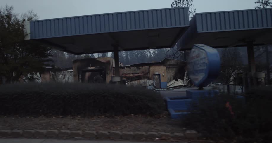 An abandoned burnt down car wash in a wooded area