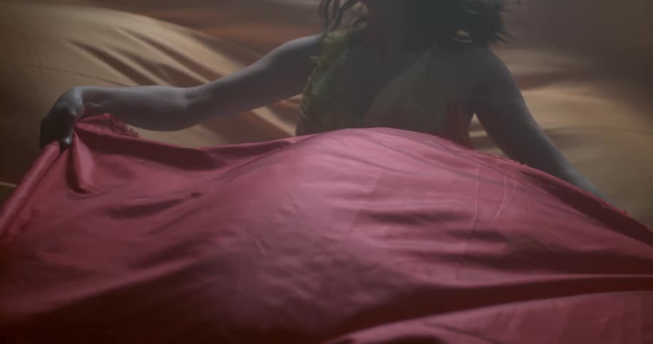 A woman dances among flowing cloth