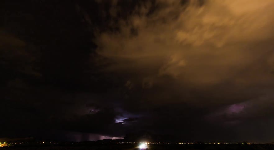 Timelapse at night with cars and headlights with an incoming storm and lightning