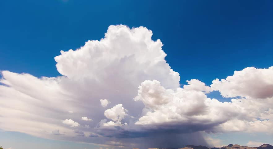 A timelapse of clouds moving across a desert and mountains