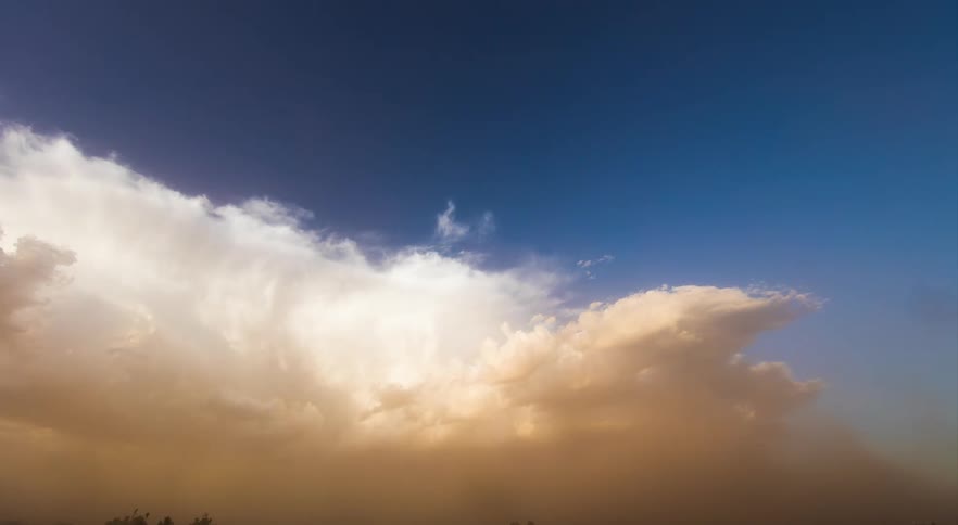 Storm system kicking up a dust cloud near a road
