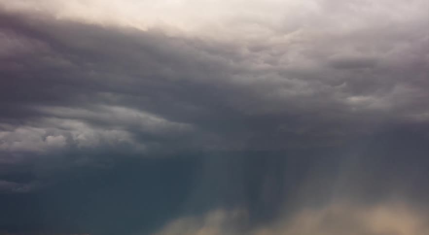 Large storm cloud rolling across pasture in rural area