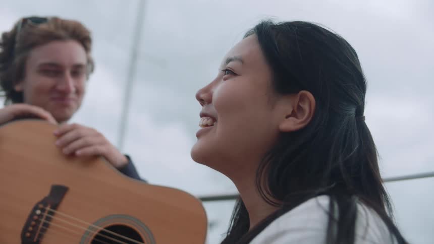 Close up of a happy relaxed couple of teens talking and joking on a sailboat