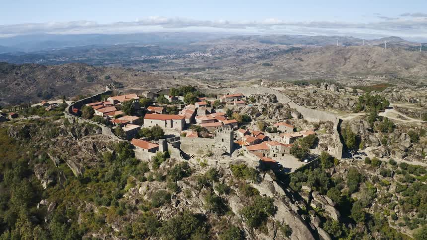 A castle like building sits atop a hill over a neighborhood