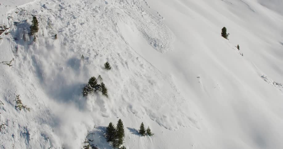 Snow slides down the side of a mountain