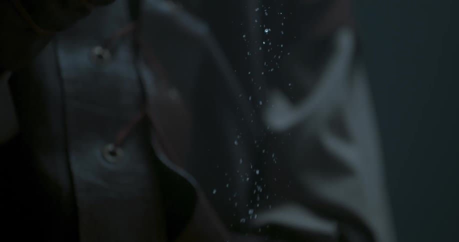 A hand drops particles into another, open hand