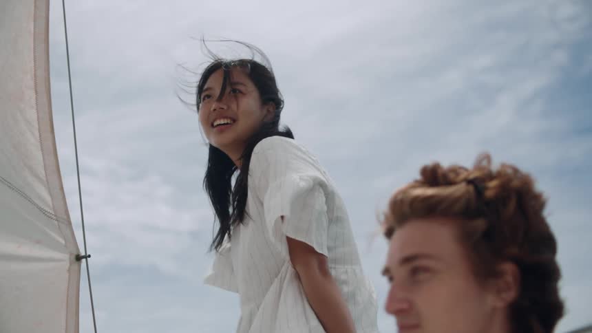 Two friends are sitting on a boat and smiling