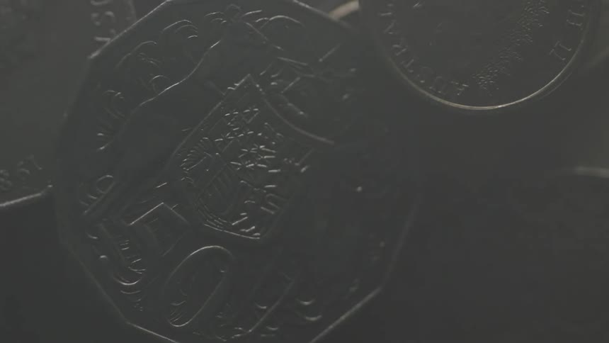 A light slowly turns on some coins
