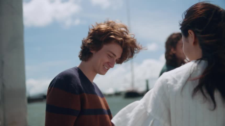 A group of friends meets up on boat on a windy day cuddling and laughing