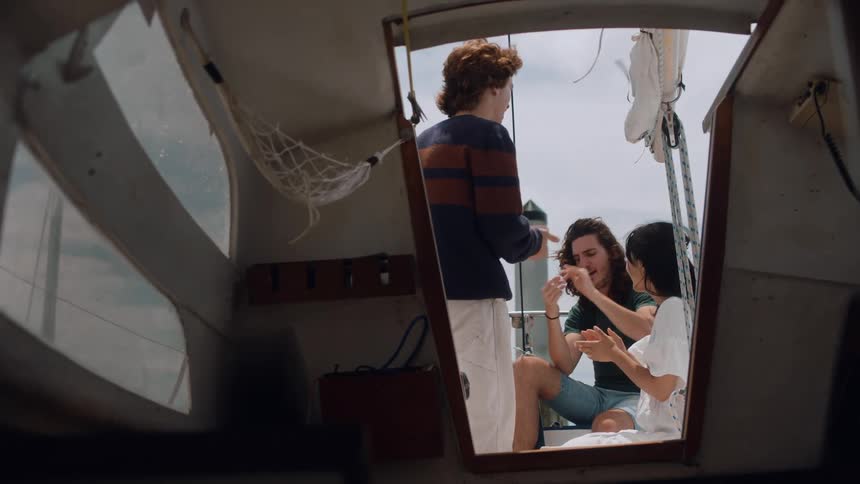 Friends clap and talk outside the boat