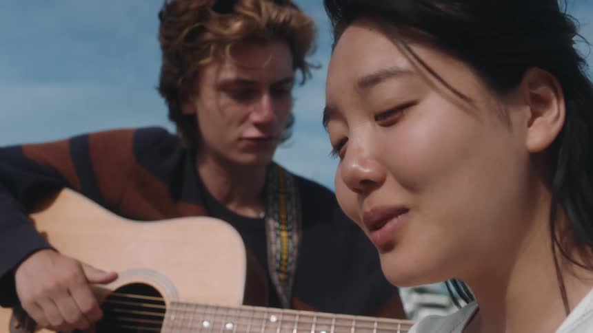 Two friends are singing and playing guitar together