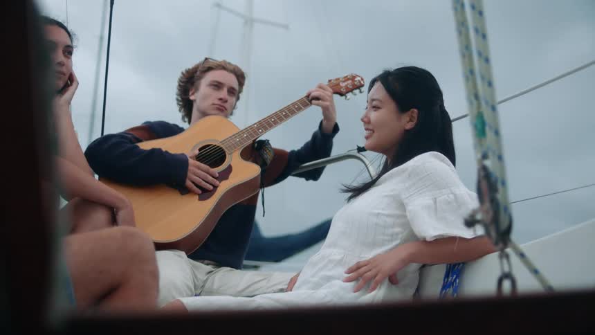 A man plays guitar as friends listen