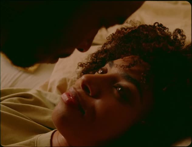 Man and woman lying in bed kiss and exchange i love you