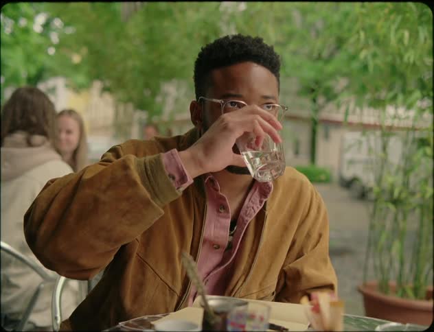 A man takes notes and drinks water