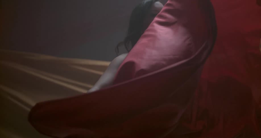 Woman twirls a large red sheet around