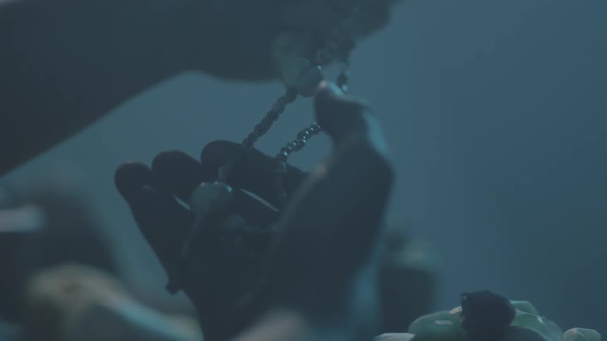 A person examines a necklace