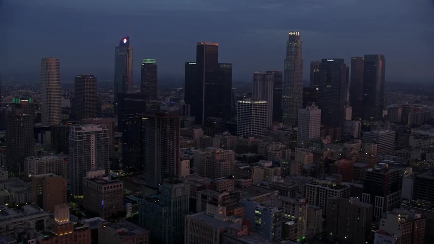 Aerial footage of downtown Los Angeles skyscrapers during sunrise on a cloudy winter morning in California