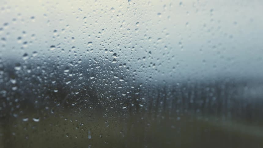 Raindrops run down blurry window