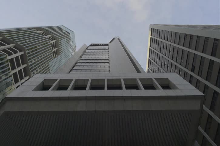 Looking up at towers and skyscrapers with amazing architecture as lights glow in the darkness as daylight arrives
