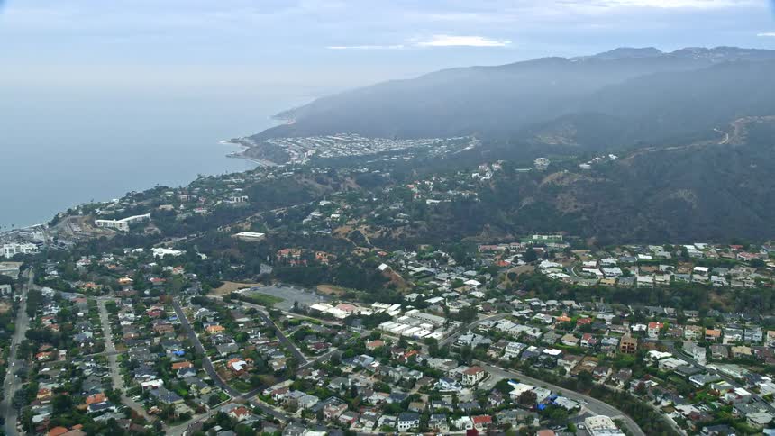 An aerial shot at sunrise flying over Palisades Charter High School and coastal neighborhoods in Pacific Palisades California