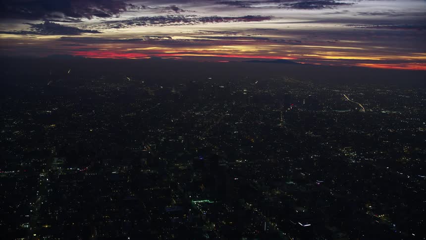 Aerial footage of approaching Downtown Los Angeles skyscrapers at sunrise in winter