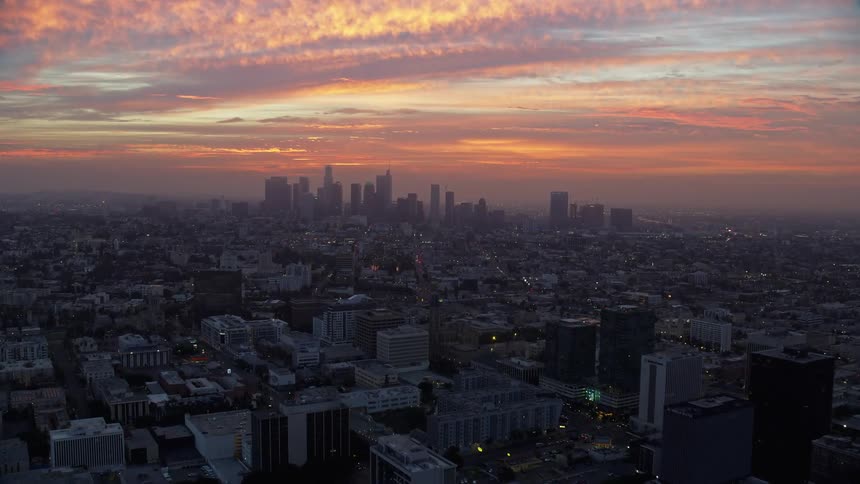 Golden clouds engulfing Downtown Los Angeles California during early morning with a breathtaking view of tall skyscrapers in the city skyline shot during winter