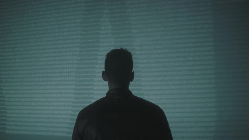 Man looks at a projection on a wall