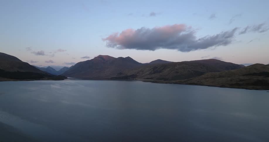 Aerial view of a mountain range on the coast of a lake at evening