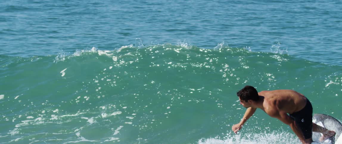 A surfer rides a wave as water splashes over his head
