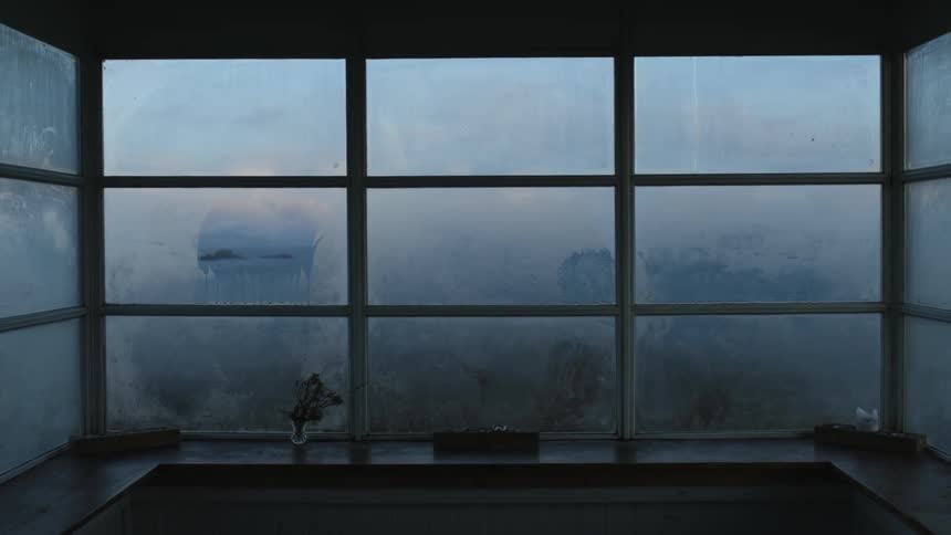 Foggy windows on the balcony obscure the view at evening