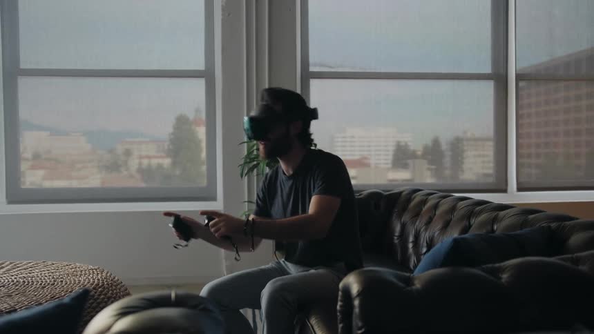 A man speaks animatedly while using a virtual reality headset