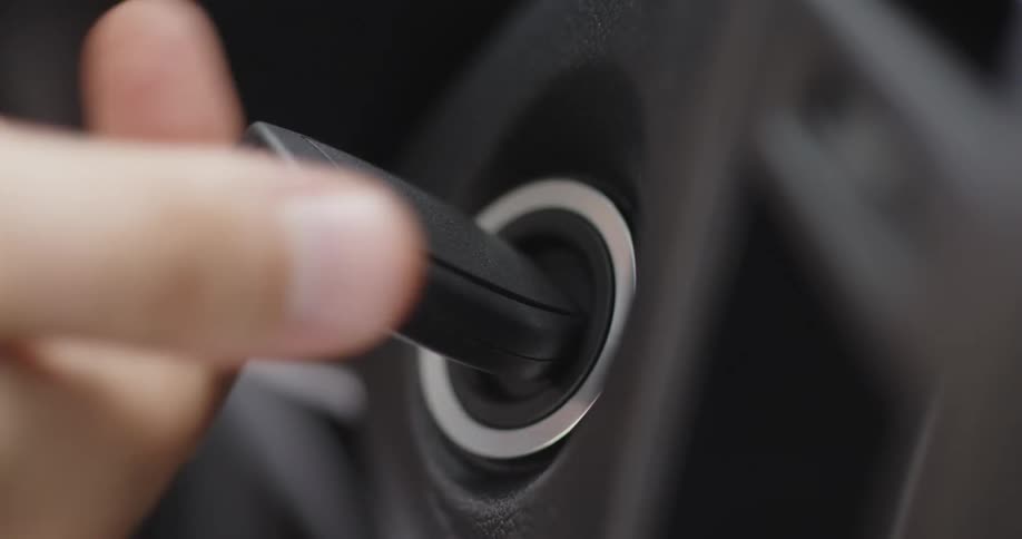Mans hand turning ignition key in car