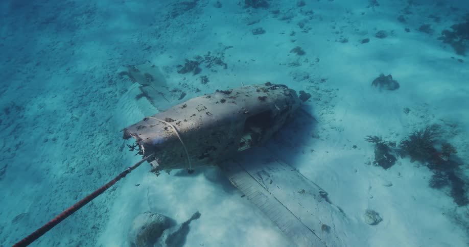 Underwater footage of the remains of a sunken airplane resting at the bottom of the ocean