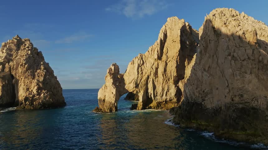 Waves crash onto rocks below cliffs in the ocean