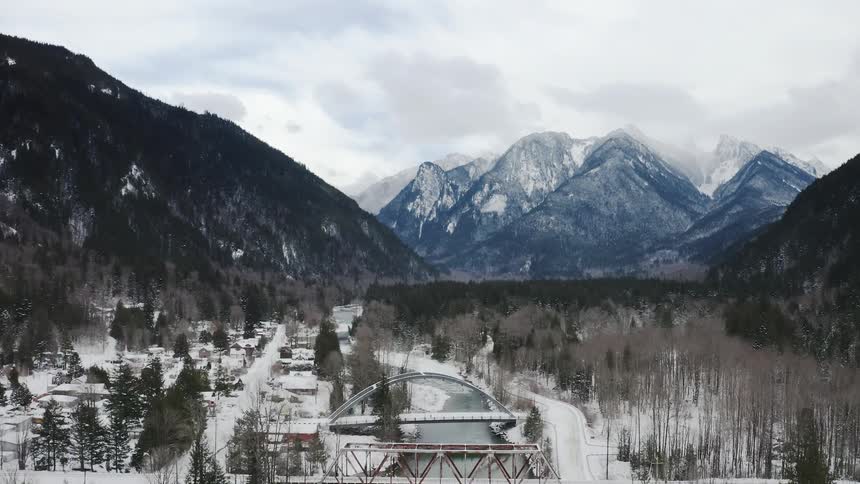 A breathtaking mountain landscape unfolds before us with snowcapped peaks rising majestically into the sky