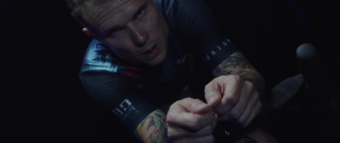A mans face with sweat on it as he cycles on a stationary bike