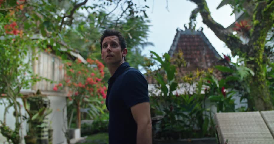 A man is walking through a yard
