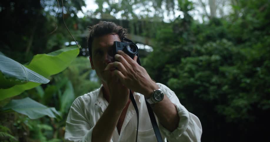 Young photographer takes picture of the green lush vegetation of a tropical forest