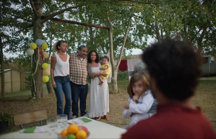 A man poses with his daughters and grand daughter at a celebration in their yard