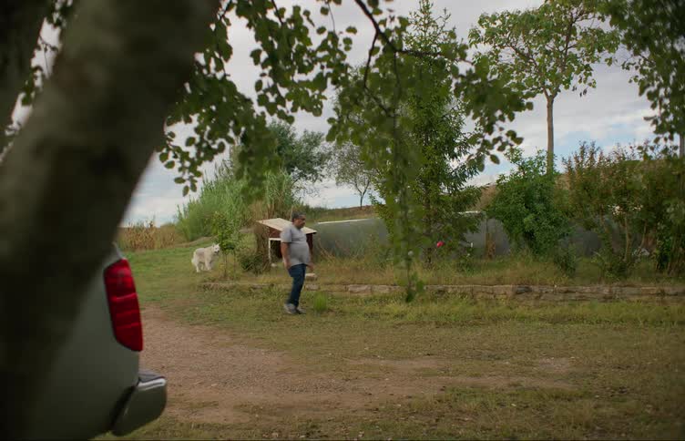 A man is walking outdoors in the middle of the day