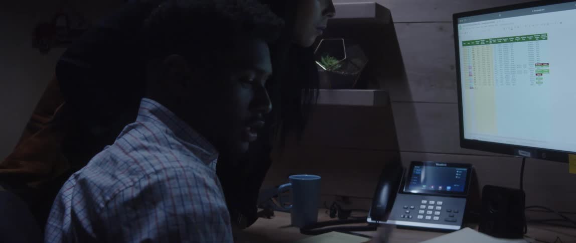 A man and woman talking and looking at the computer screen