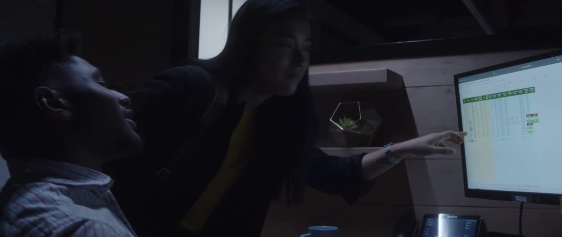 Businessman and businesswoman work on computer in the office at night